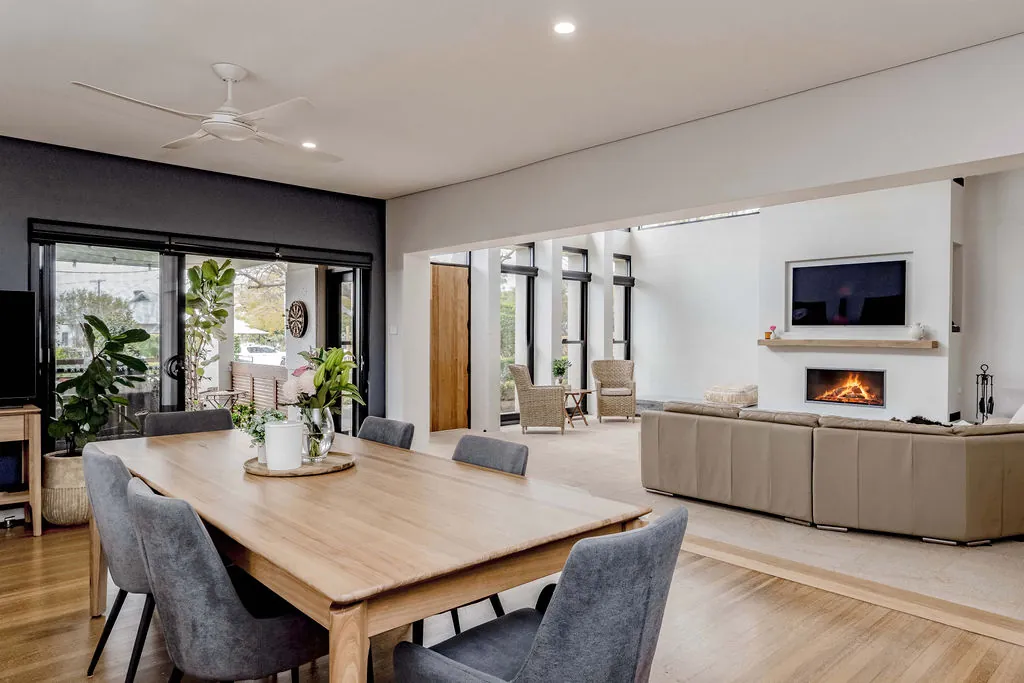Dining area flowing into the new lounge room with the fire lit