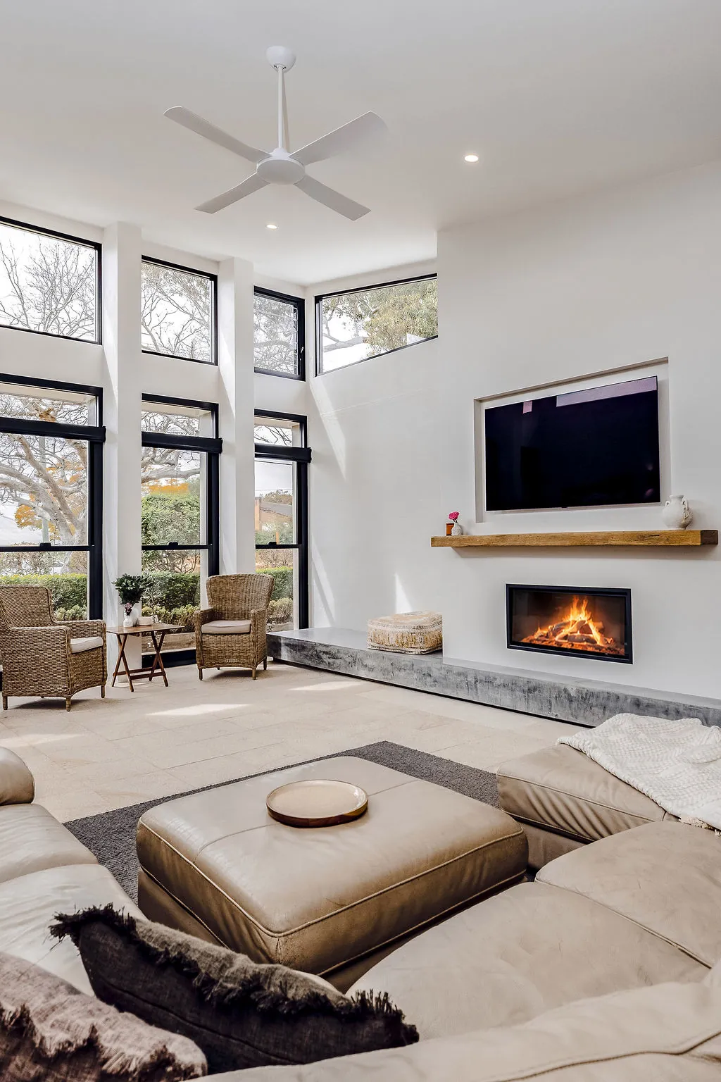 Fireplace on a burnished concrete plinth below a timber mantel