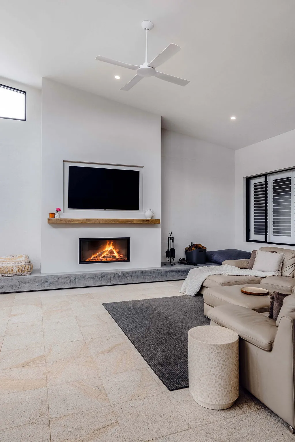 Burnished concrete plinth running the length of the fireplace wall